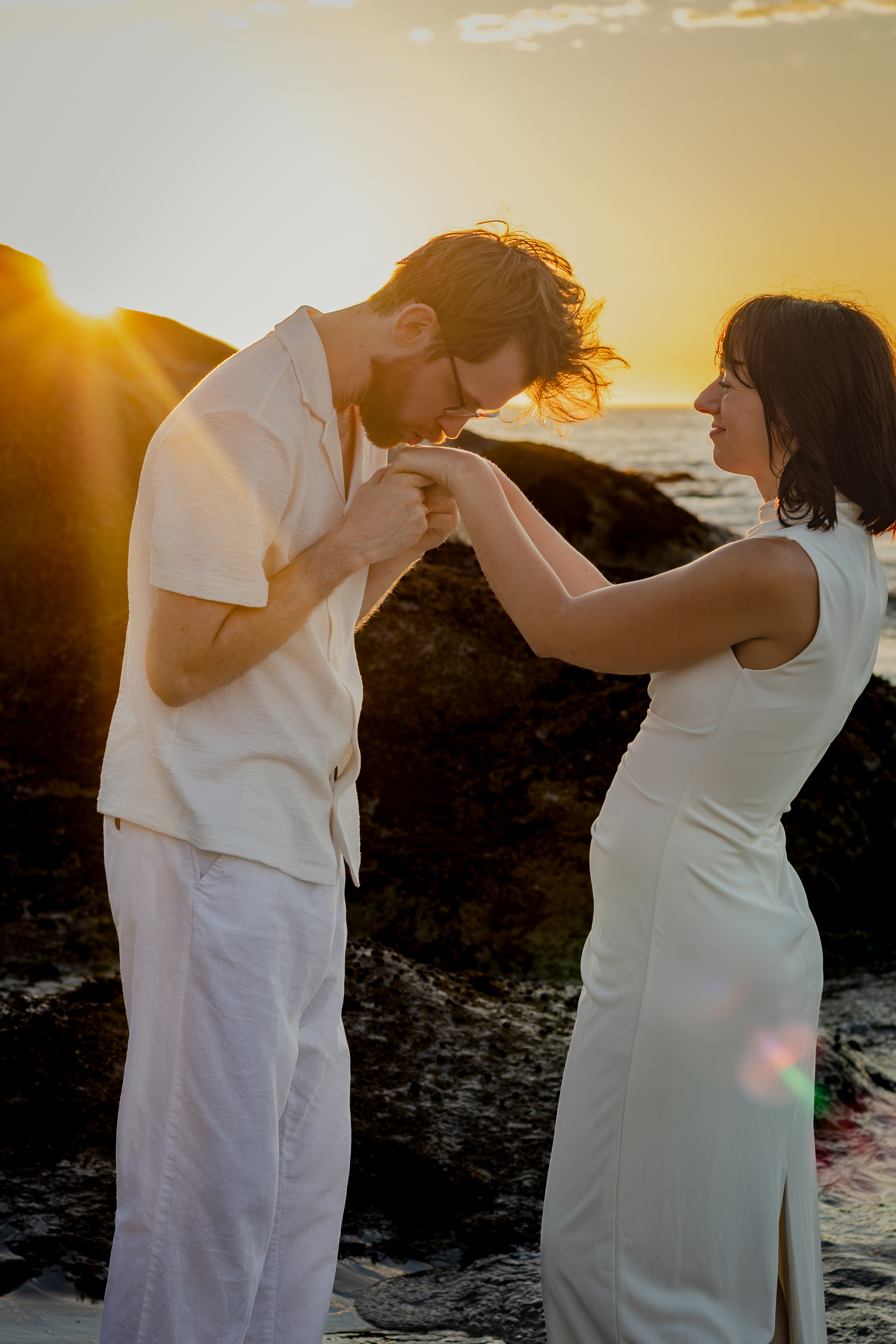 Couple standing closely together near the rocks